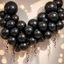 Party Paradise Store black metallic latex balloons arranged in a decorative arch with curled ribbons