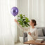 Party Paradise Store purple chrome latex balloon floating near a woman in a bright living room