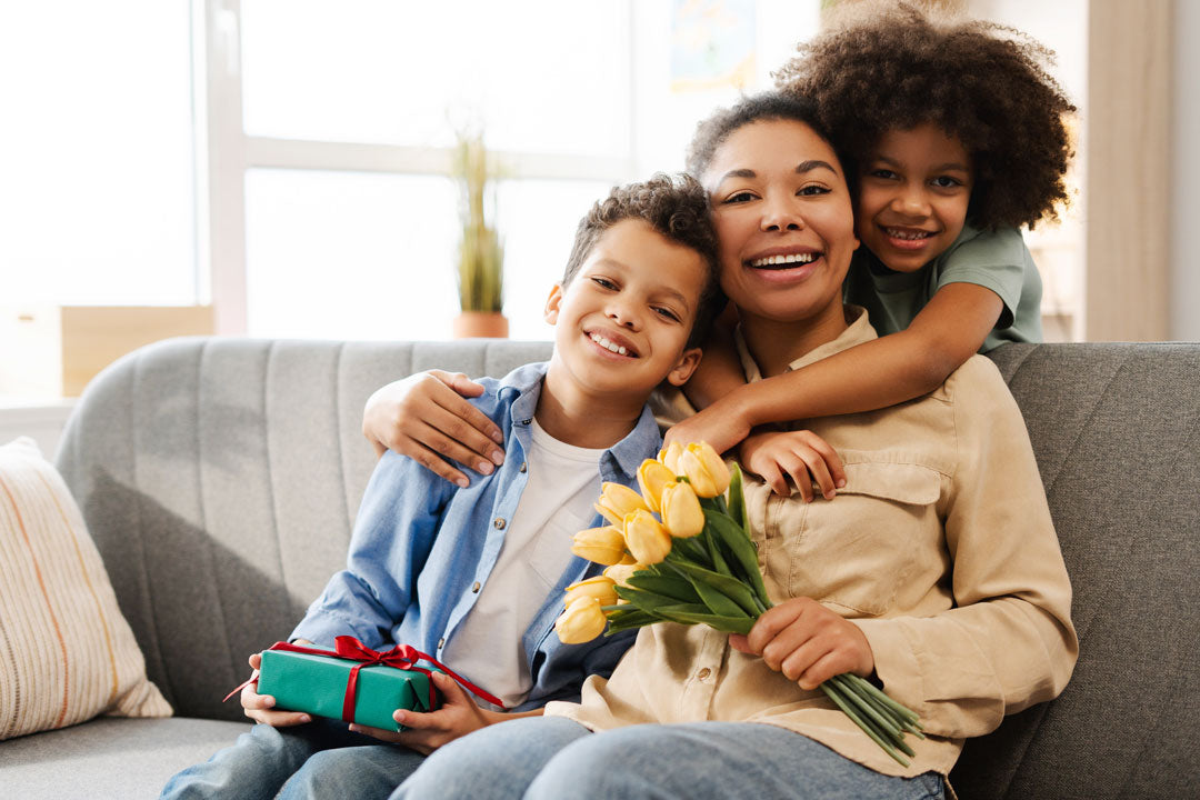 Smiling family with flowers and gift, perfect for birthday party supplies or holiday decorations, creating joyful celebrations.