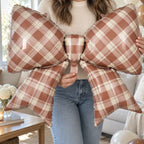 Party Paradise Store brown gingham plaid bow foil balloon held by a person for fall party decorations.