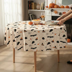 Party Paradise Store round Halloween table cover with cute bat, ghost, and witch hat patterns on a cream background