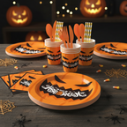 Party Paradise Store Halloween tableware set with jack-o'-lantern plates, cups, and orange cutlery on a wooden table.