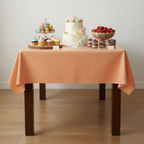 Party Paradise Store reusable orange plastic table cover on a dining table set with desserts for a party.