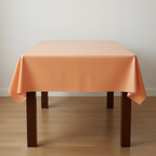 Party Paradise Store reusable orange plastic table cover draped over a wooden table for indoor or outdoor events.