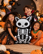 Party Paradise Store skeleton cat foil balloon held by three children in Halloween costumes at a festive party.