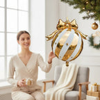 Party Paradise Store white and gold Christmas ornament balloon with a bow, hanging in a festive living room.